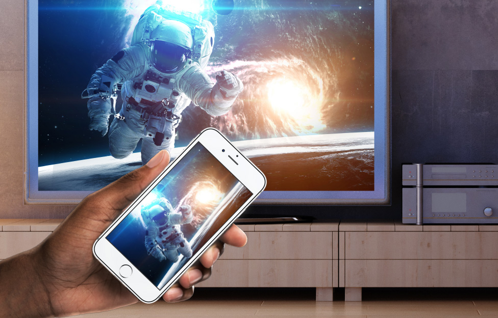 man holding phone in front of tv with an astronaut on it